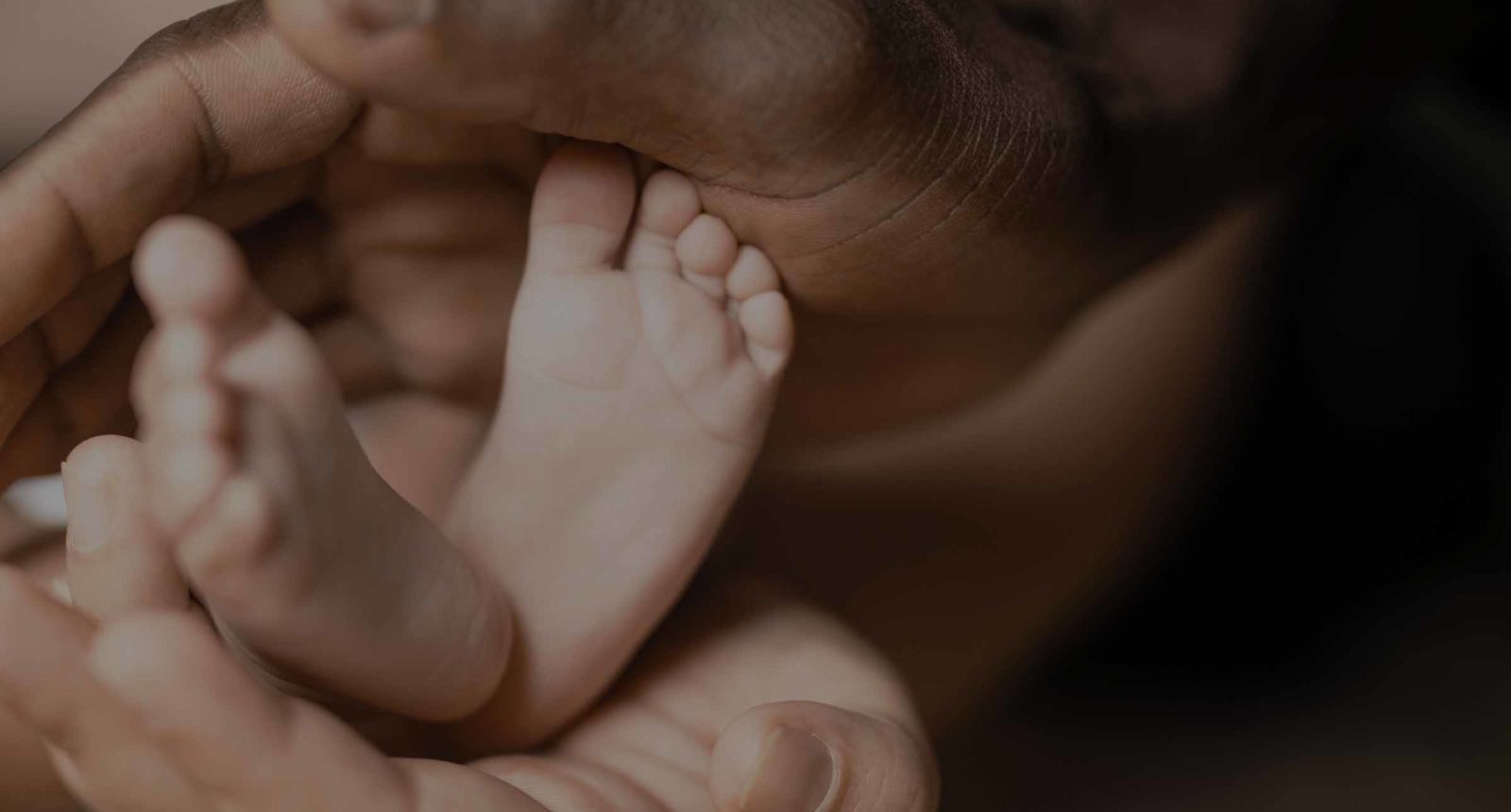 Family holds newborn baby's feet after experiencing birth injury