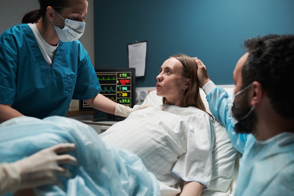 Woman in labour in hospital bed